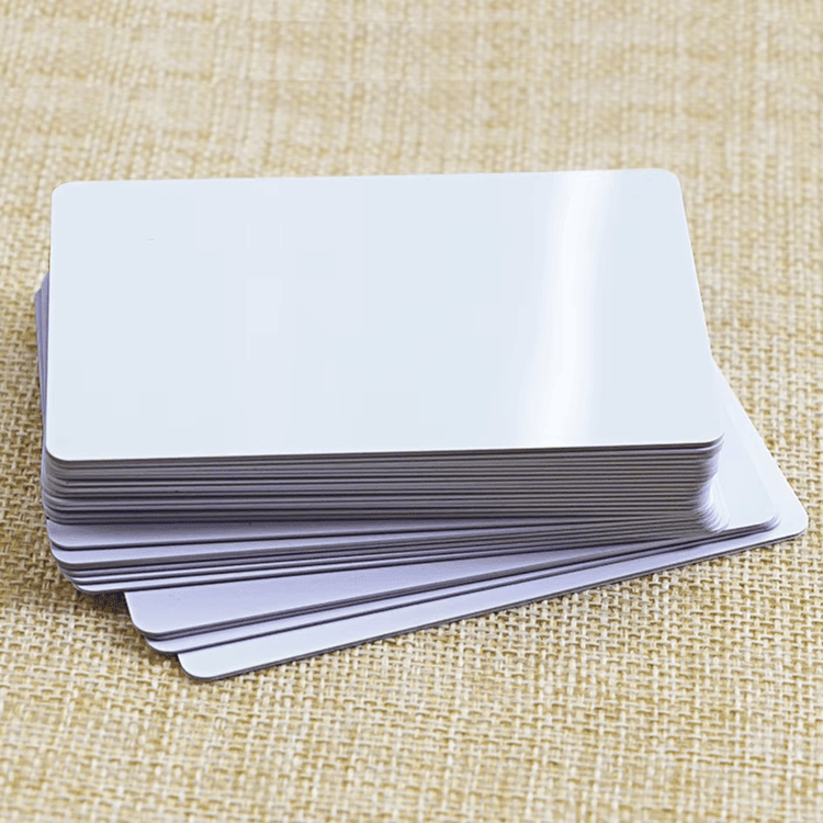 Blank inkjet PVC cards are stacked on a textured fabric background to present a realistic event pass card printing scene.
